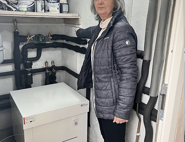 Resident Caroline Bolitho turning on her Kensa Shoebox heat pump for the first time