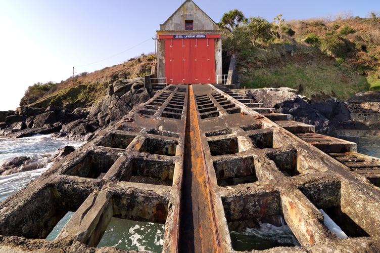 Penlee Lifeboat House and Slipway, Penlee Point, Mousehole, Cornwall.
General view of east elevation showing lifeboat house doors and roller slipway with sections of pre-cast reinforced-concrete grids with metal keelway, view from east. Built 1911-13 to a design by W. T. Douglass, engineer and architect to the Royal National Lifeboat Institution.