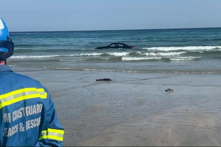 Video grab as footage shows a convertible BWM washed out to sea after parking on the beach with the coastguard joking: You cant park there! The vehicle believed to be a E93 soft top was filmed off Trevaunance Beach, Cornwall, this morning (Sun). See SWNS story SWMRcar. St Agnes Coastguard Search & Rescue Team said they were called to the beauty spot at around 8.30am, where they first made sure there was no one in the car.Their teams then remained on scene whilst recovery efforts took place, before the flashy sports car was finally removed by a tow truck off the beach.