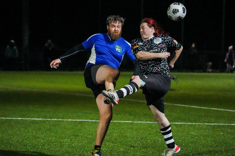 HALYE, CORNWALL, ENGLAND - February 4th 2024 : Players from Hall for Cornwall (in blue) and Stargazy FC, Cornwall's first LGBTQ+ football club, challenge for the ball during their match, photographed by HfC photographer in residence Hugh Hastings.
