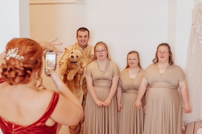The wedding of Kayrin Callaghan to Alex Slater-Brown, involving some of the adults carer Kayrin looks after as part of the bridal party; including Jamie Kevern, 26,  Daisy, 18, Francesca, 20, and Chloe, 26 - all of whom have has Down syndrome. Photo released April 18 2024. A carer surprised the adults she supports by asking them to be her bridesmaids.Kayrin Callaghan, 30, instantly knew she wanted the adults she supports to be a special part day when her fiancÃ©, Alex Slater-Brown, 25, a hospital care assistant, proposed. The mom-of-two has supported Jamie Kevern, 26, who has Down syndrome, for two years.Kayrin also helps Daisy, 18, Francesca, 20, and Chloe, 26 - who also have Down syndrome - and stuck up a special bond with them all - enjoying days out to the local swimming pool and cinema together. 