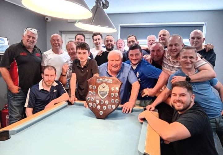 Members from both teams in front of the Roger Stephens Shield.