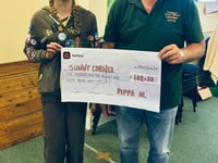 Brownie Pippa gives cheque to Sunny Corner