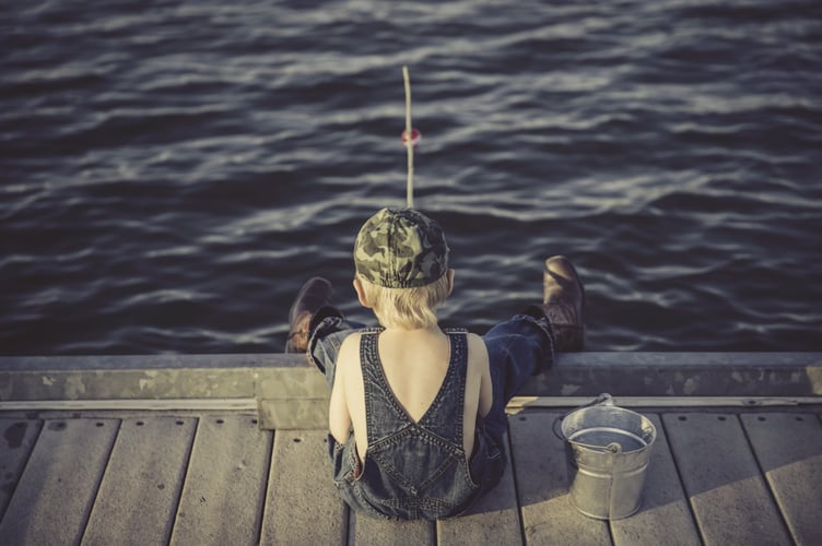 Boy fishing from jetty