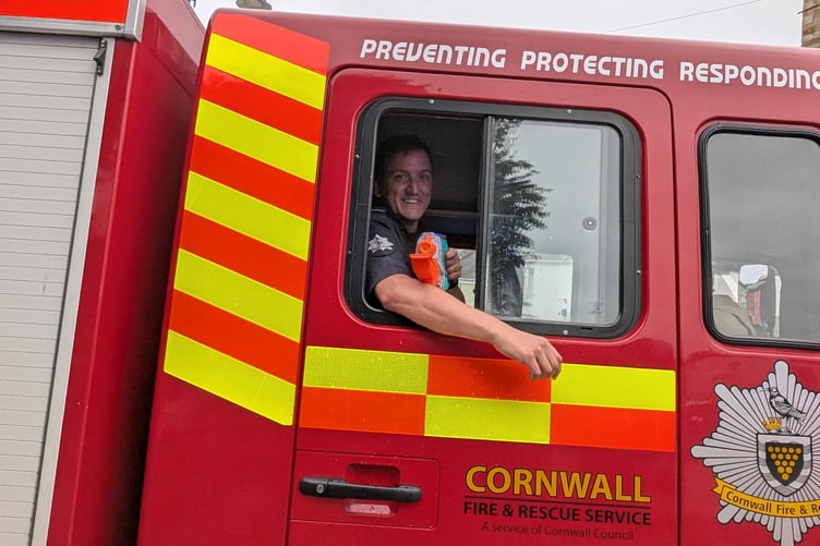 Sam Goodswen of the Cornwall Fire and Rescue service dampens the heat of the day by dousing the crowd with a water pistol
