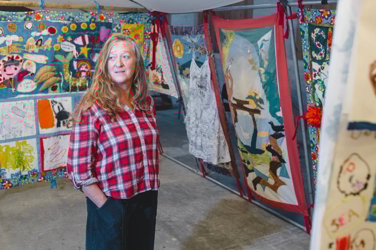 Bec Applebee, the artist behind Story Shelter, photographed in front of Story Shelter panels at East Pool Mine(C)National Trust Images_Steve Haywood(4)