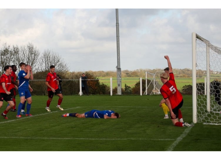 Delight and despair in equal measure as Dobwalls' players celebrate after Charlie Castlehouse's free-kick was helped into the net by Newquay midfielder Cam Turner. Picture: Colin Hilton