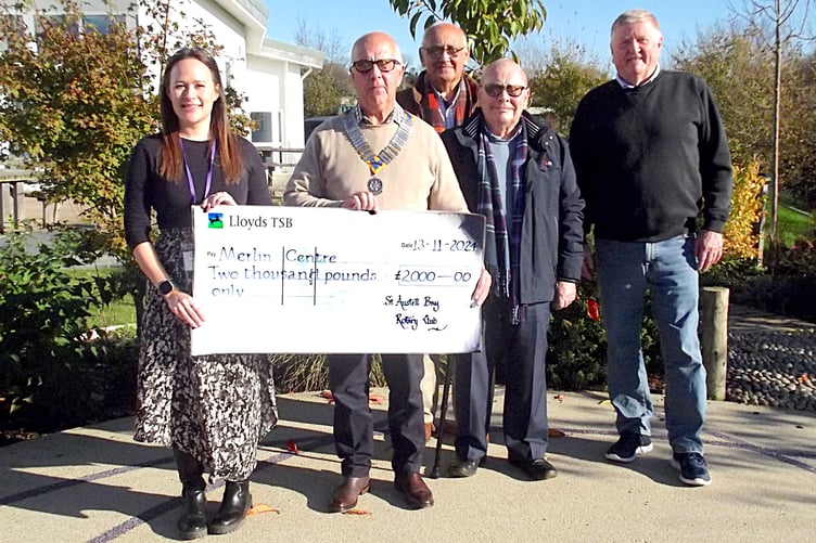 Club president Paul Hancock gives the giant cheque to Sammy Thompson.