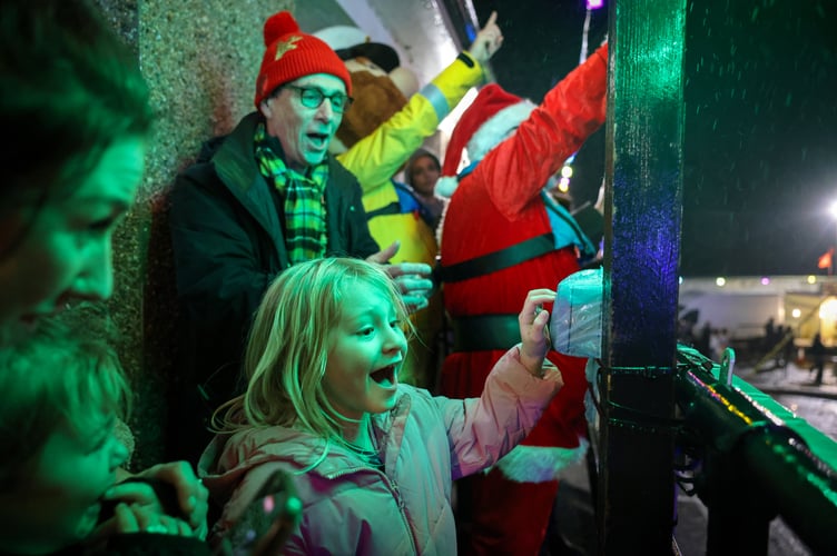 As the countdown reaches one, Luna presses the button to switch on the lights. Santa swaps his sleigh for a lifeboat as Storm Darragh approaches at the Newlyn Harbour Lights Grand Switch On on Friday 6 December. Photo by Penzance Council