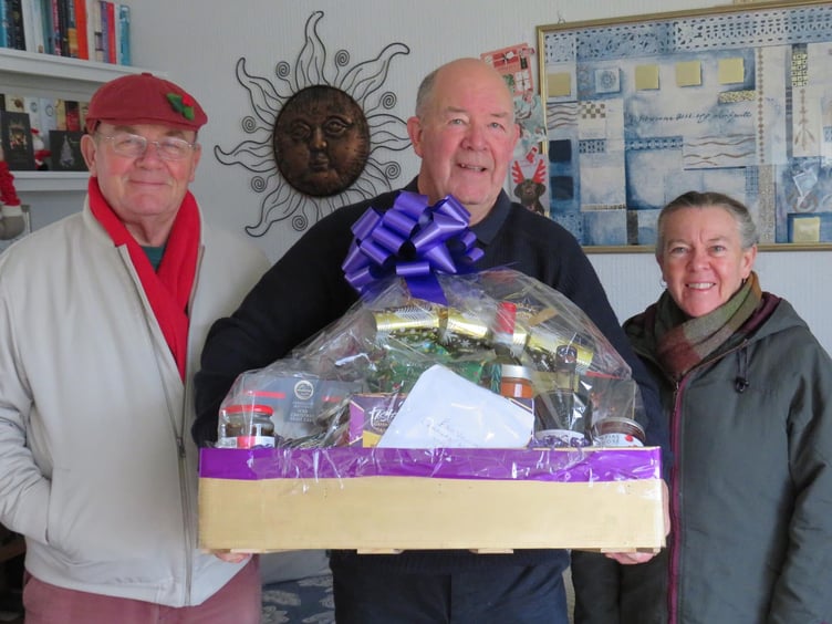Lion Geoff Kaye presents a prize hamper to winners Frank and Sue Found from Veryan
