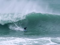 Surfers tackle huge waves at the Cribbar