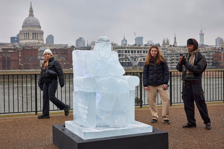 Visitors taking a look at the Ice sculpture of Rob Trewhella outside Tate Modern.