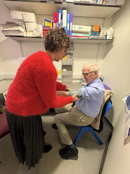 Pharmacist Judit Barta with member of the public having his blood pressure checked