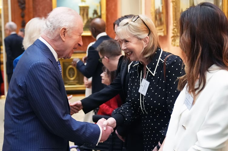 King Charles III shakes hands with Fern Britton during a reception at Buckingham Palace celebrating exceptional individuals and organisations contributing towards humanitarian efforts across the globe 