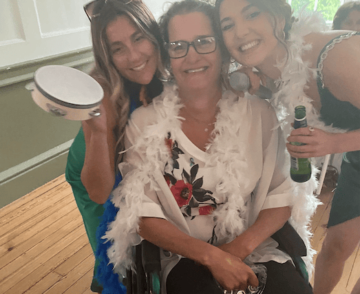 Woman taking part in marathon in a wheelchair pushed by her family