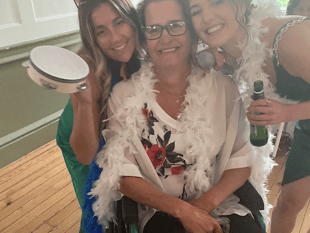 Woman taking part in marathon in a wheelchair pushed by her family