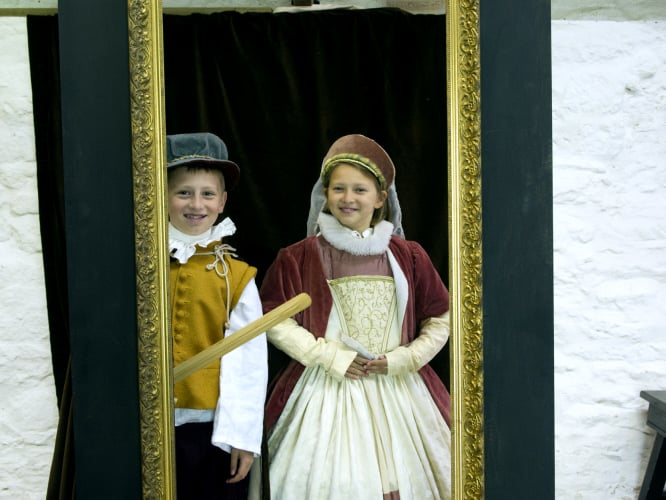 Visitors dressing up in historical costumes at Trerice, Cornwall.