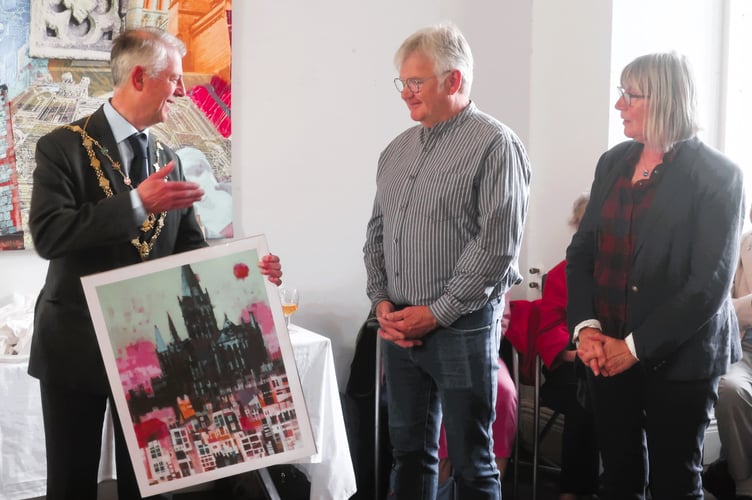Mayor of Truro Chris Wells presents a print of Truro Cathedral to two Morlaix representatives