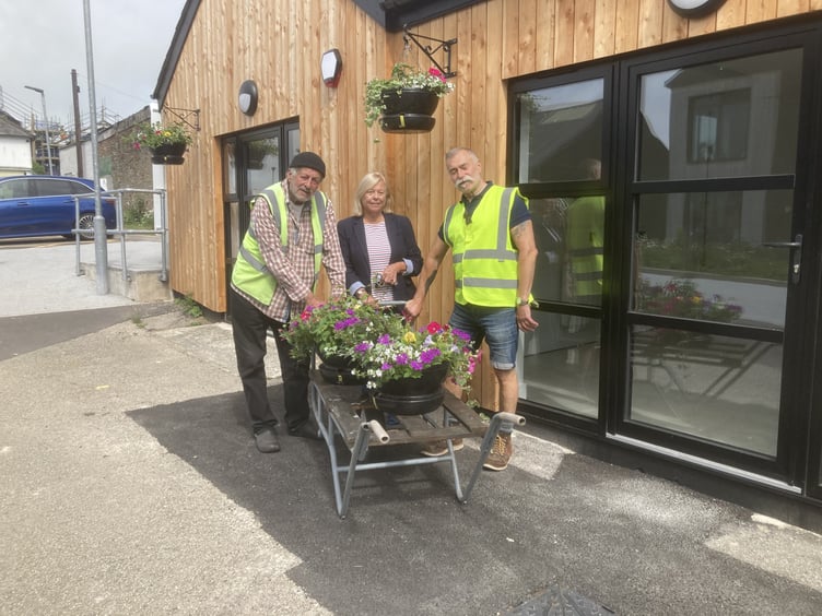 Pictured hard at work for Liskeard in Bloom are John Crumpton, Jane Pascoe and John Hesketh hanging the new floral baskets at the newly refurbished work units in the Cattle Market