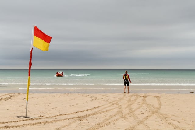 RNLI lifeguards patrolling beach rescue swimmer