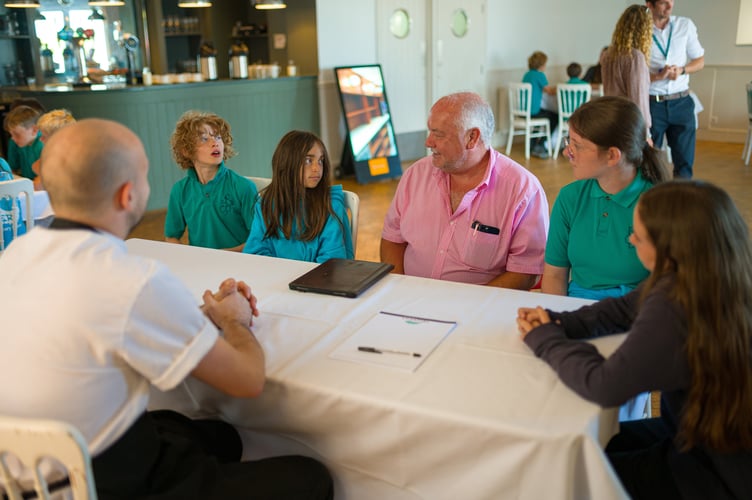 Andrew Long, owner of Hotel Polurrian, head chef, and Mullion Primary School pupils.