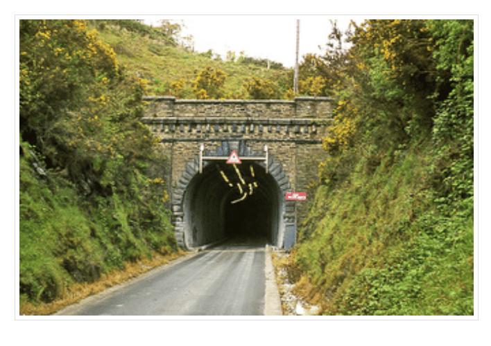 Barrie says of this photograph: “Years ago before Dr Beeching used his axe and closed a lot of the railways it was possible to use this tunnel. You could catch the train at Lostwithiel and then via Golant, Fowey, Par, St Blazey and beyond finish up at Newquay.  “The line was closed & ECLP took out the line or buried it in tarmac and installed traffic lights and overhead lighting for lorries carrying clay between Par & Fowey docks. Now millions are being spent installing a new line to connect up some of the venues again. There are times during the year when the tunnel is open for cyclists to ride through it. This is the view at the Ship Inn end.”