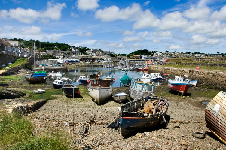 Exterior view of Newlyn's Old Harbour, showing the Old Quay with various fishing vessels anchored on the shingle beach

© Historic England Archive