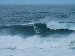 Surfers tackle huge waves generated by hurricane Erin