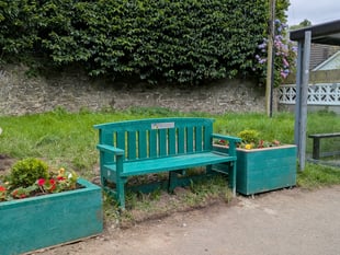 New bench and planters at bus stop outside railway station