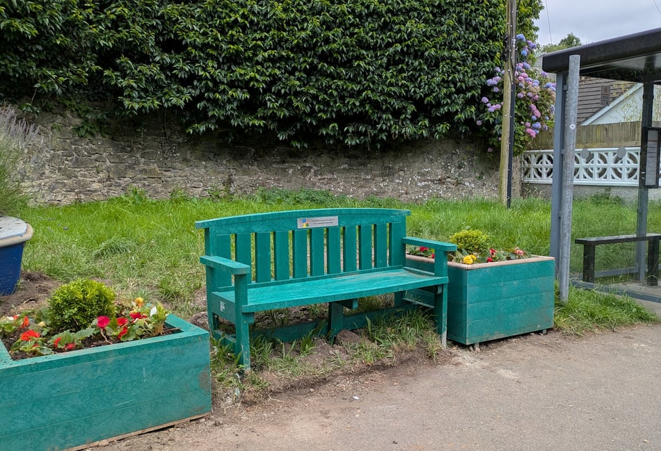 New bench and planters at bus stop outside railway station