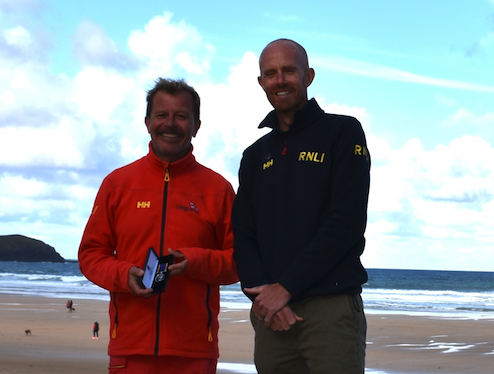 (L-R) Jason Walsh being presented with his long service award by regional lifeguard lead Guy Botterill (Picture: Newquay RNLI lifeguards)