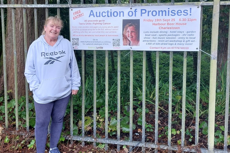Kym Robinson with a banner featuring Tabitha’s photograph.