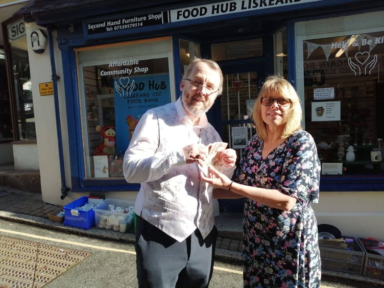 Geoff Lewis, a volunteer at the Food Hub Liskeard CIC, receives £50 from Tracy Adams, chair of the Liskeard Traders Association