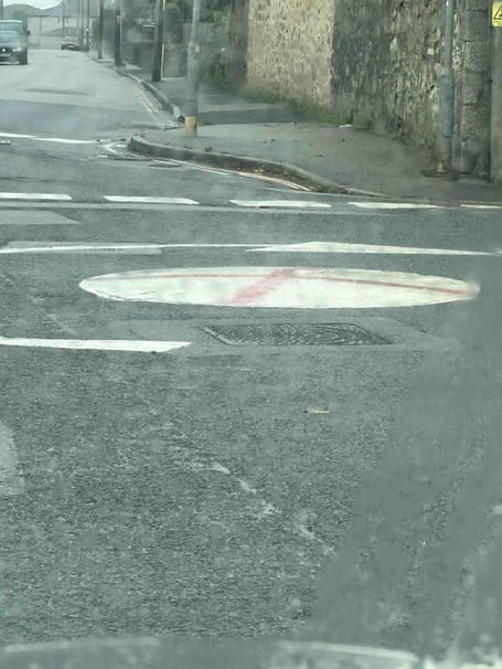A roundabout in Camborne which is the latest to be daubed with the St George's cross (right)