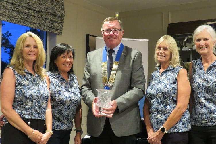               Truro Lions president Julian Collinson presents the crystal trophy to the winning ladies' golfing team                   
