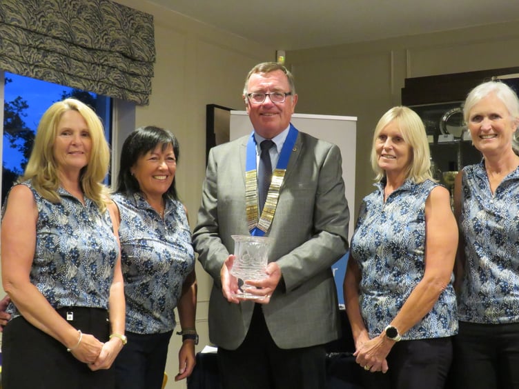 Truro Lions president Julian Collinson presents the crystal trophy to the winning ladies' golfing team