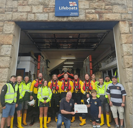 Dylan handing over the cheque to Newquay RNLI Lifeboats (Picture: Charlotte Jane)