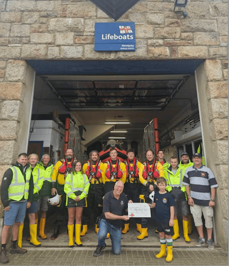 Dylan handing over the cheque to Newquay RNLI Lifeboats (Picture: Charlotte Jane)