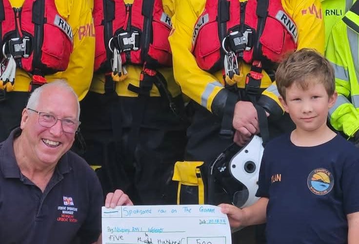 Dylan hands over the cheque to Newquay Lifeboat Station's operations manager Gareth Horner (Picture: Charlotte Jane)