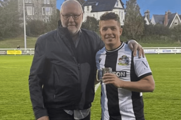 Archie Reynolds receives a tankard from Penzance chairman Godfrey Adams to commemorate his 100th South West Peninsula League start. Picture: James Wright.