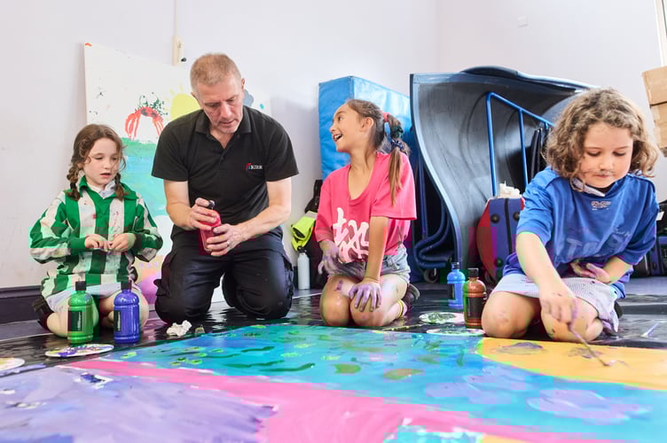 Environment Agency and Kier staff painting hoardings with students at Mousehole Primary School.