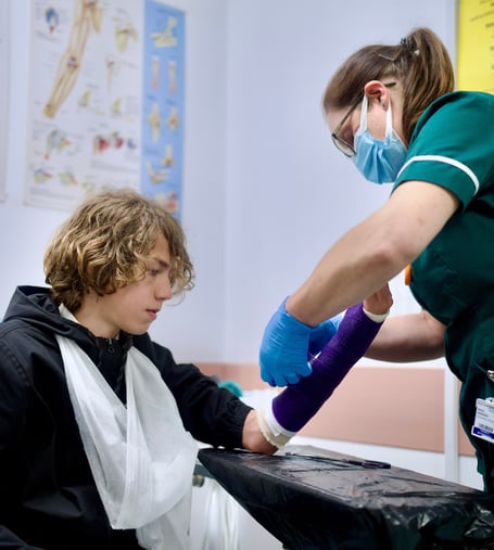 Boy with arm  in sling and nurse