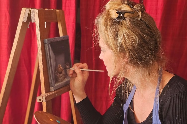 Artist Lucinda Holland at work on a painting.
