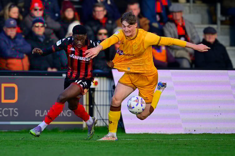 Dominic Johnson-Fisher of Truro City battles for the ball with Jack Taylor of Sutton United during the National League match between Truro City and Sutton United at Truro City Stadium on 22 December 2025 Photo: Phil Mingo/PPAUK