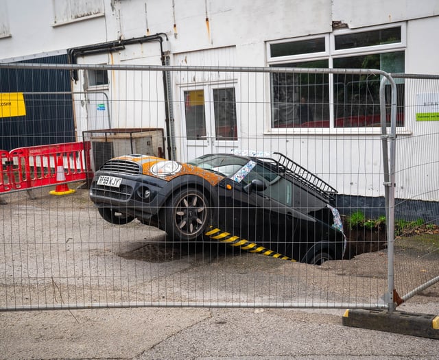 Officials still trying to figure out how to move car from sink hole