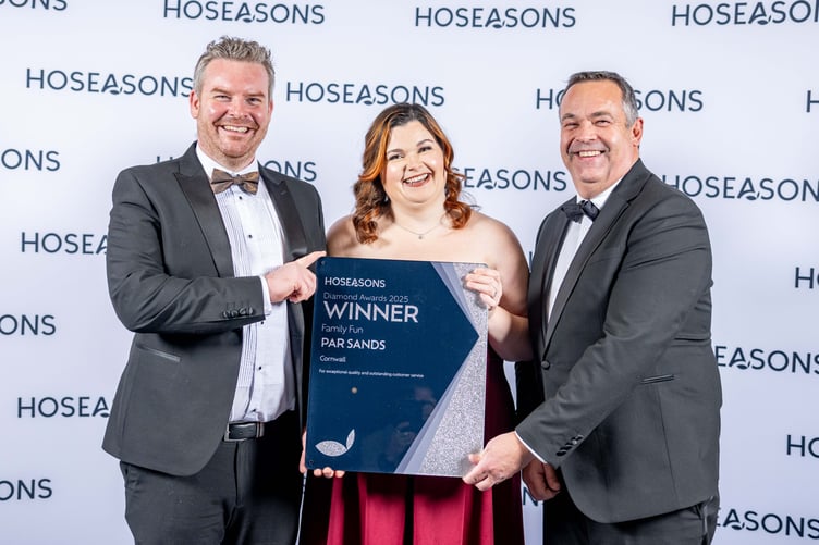 Simon Fuller and Becky Jackson from the Par Sands holiday park receive the award from Neil Davies of Hoseasons (right).