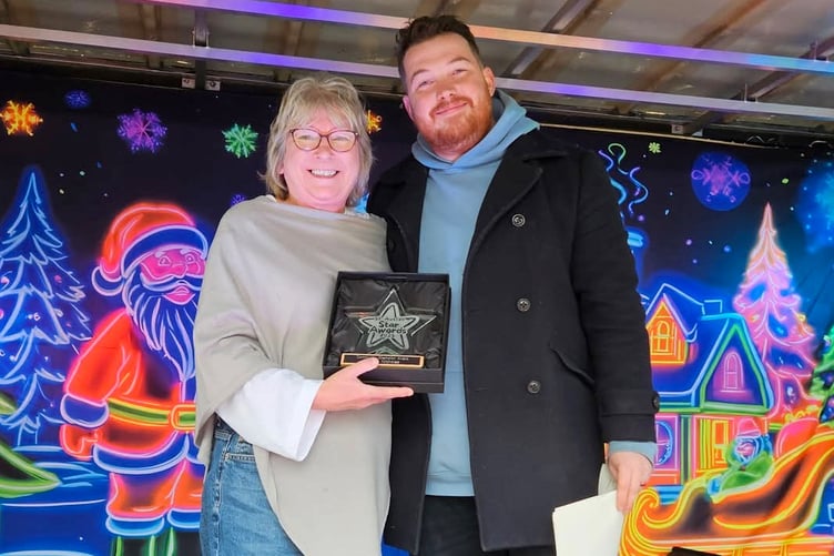 Teresa Nicholas receives her community champion award from Jake Richards.