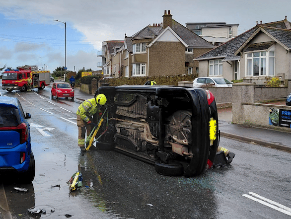 Main route closed after car rolls onto its side 