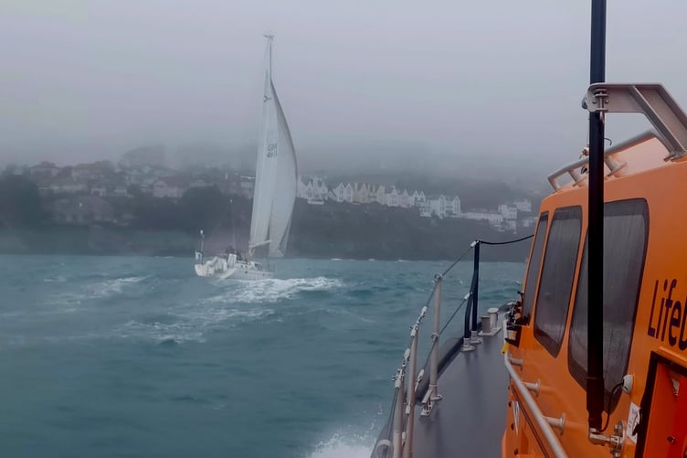 The yacht that suffered an engine fire shown being escorted into Fowey. (Picture: RNLI)