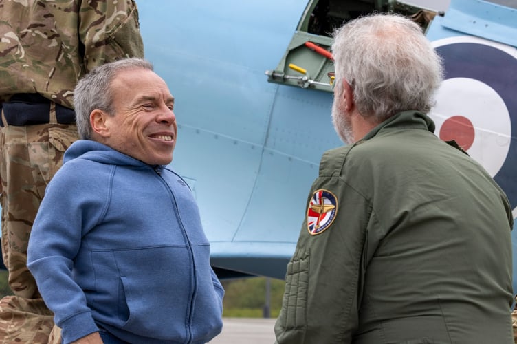 Image shows actor Warwick Davis in conversation witb passenger for this leg, Mr Ian Wood after landing at Cornwall Airport Newquay. A historic RAF Spitfire touched down in Cornwall today as part of the nationwide Spitfire 90 Tour, marking 90 years since the iconic aircraftâs first flight and raising funds for two important RAF charities.The legendary aircraft arrived at Cornwall Airport Newquay (CAN) at 1148 hrs on Thursday 16 April, drawing aviation enthusiasts, personnel and special guests eager to witness a living piece of British history.The visit formed part of the Spitfire 90 Tour, delivered by Spitfire.com and supported by the Battle of Britain Memorial Flight. The tour commemorates the Spitfireâs first flight in 1936 and aims to raise funds for both the Mark Long Trust and the RAF Benevolent Fund, supporting serving personnel, veterans and their families.Despite bestlaid plans, unpredictable weather required adjustments to the flyingprogramme, resulting in the Cornwall visit taking place on Thursday 16 April rather than the originally advertised date, Wednesday 15 April. The changes highlighted the complexities of operating historic aircraft and the importance of safety led decision making.Among those fortunate enough to witness the Spitfire on the ground was BAFTAawardwinning actor Warwick Davis.